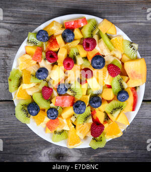 Vista dall'alto di una macedonia di frutta fresca con banane kiwi mirtilli arancione e pesca Foto Stock