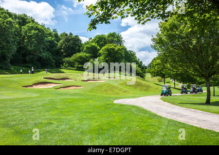 Un bunker e putting green con flagstick e foro su un tipico campo da golf. Foto Stock