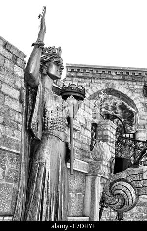 Scultura artistica di Illyria davanti al muro di pietra BW Foto Stock