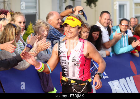 Tenby, Pembrokeshire, Wales, Regno Unito, 14 settembre, 2014. I corridori che attraversa la linea di arrivo durante la 26 miglio girare intorno Tenby, Pembrokeshire. L'Ironman Galles evento inoltre consisteva di un e un 112 miglio cycle race e un 2.4 miglio nuotare questa mattina in città. Credito: Andrew Bartlett/Alamy Live News Foto Stock