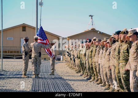 Le forze della coalizione nel Comando regionale sud-ovest salutate come gli Stati Uniti bandiera è sollevata durante il 9/11 commemorazione Settembre 11, 2014 a Camp Leatherneck, provincia di Helmand, Afghanistan. Foto Stock