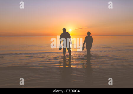 Coppia senior passeggiando al tramonto Foto Stock