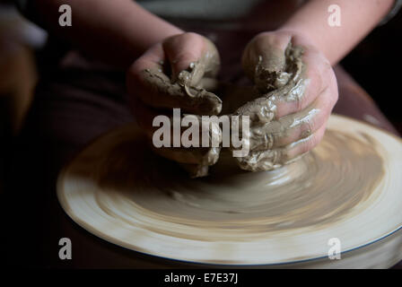 Mani femminili formando pentola di creta sulla ruota in ceramica Foto Stock