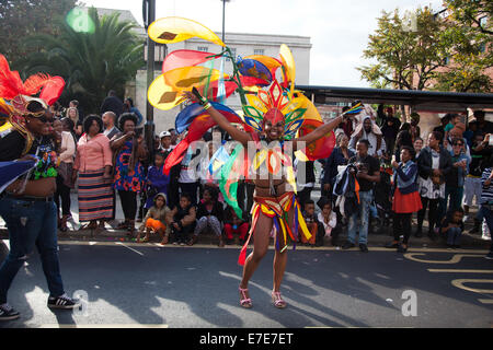 Una Donna vestita di piume colorate pongono di fronte all'Hackney Municipio dove fortunatamente pubblico incoraggiante a guardare. Foto Stock