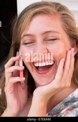 Donna felice parlando al telefono Foto Stock