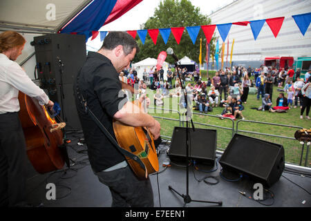 Gente radunarsi per appendere fuori, ascoltare le bande e altre attività presso la Blue Ribbon Village. Thames Festival Londra UK. Foto Stock