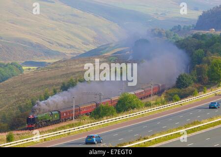 Treno a vapore locomotiva per l'autostrada M6 nel fiume Lune Valley. Howgills, Cumbria, Linea principale della Costa Occidentale, Inghilterra, Regno Unito. Foto Stock