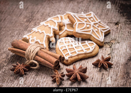 Natale iced gingerbread cookies con varie spezie su uno sfondo di legno. Foto Stock