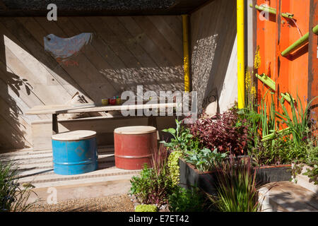 Giardino - Spazio per collegare e far crescere - Vista del giardino e realizzato da industriale recuperato e riutilizzato olio materiali Foto Stock