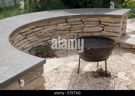 Patio circolare circolare e ricurvo Cotswold secca panca zona ghiaia e un barbecue barbecue fuoco pit area Inghilterra UK Foto Stock