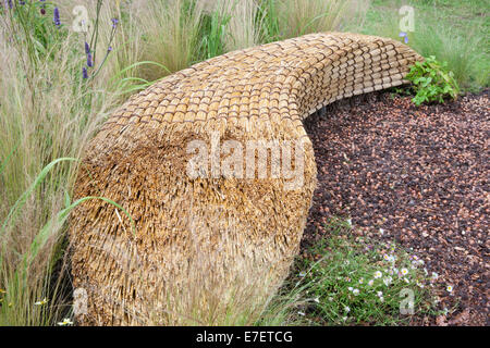 Giardino - Jordans Wildlife Garden - vista su giardino di sedile unico realizzato dal tetto di paglia di paglia con telone di nocciole - D Foto Stock