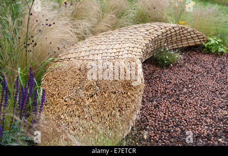 Giardino - Jordans Wildlife Garden - vista su giardino di sedile unico realizzato dal tetto di paglia di paglia con telone di nocciole - D Foto Stock