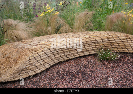 Giardino - Jordans Wildlife Garden - vista su giardino di sedile unico realizzato dal tetto di paglia di paglia con telone di nocciole - D Foto Stock