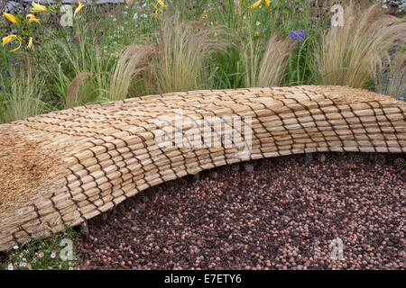 Giardino - Jordans Wildlife Garden - vista su giardino di sedile unico realizzato dal tetto di paglia di paglia con telone di nocciole - D Foto Stock