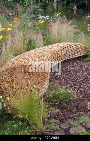 Giardino - Jordans Wildlife Garden - vista su giardino di sedile unico realizzato dal tetto di paglia di paglia con telone di nocciole - D Foto Stock