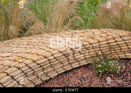 Giardino - Jordans Wildlife Garden - vista su giardino di sedile unico realizzato dal tetto di paglia di paglia con telone di nocciole - D Foto Stock