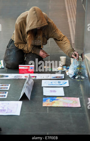 Una persona senza dimora vende artwork in Melbourne's Burke Street Mall Foto Stock