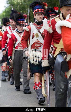 Rievocazione storica della XXXIII del reggimento di soldati a piedi in kilts andando in battaglia Foto Stock