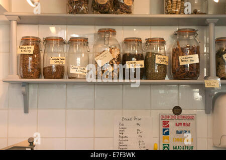 I vasetti di spezie sui ripiani con scritto a mano le etichette e i prezzi. Foto Stock