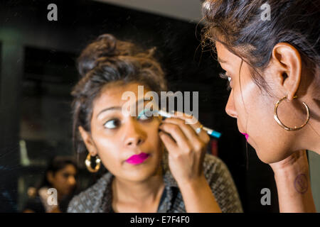 Giovane donna applicando ombretto in un make-up shop, Mumbai, Maharashtra, India Foto Stock