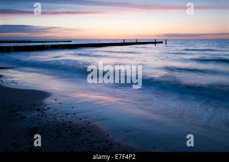 Groyne al tramonto sulla costa a, Nienhagen, Meclemburgo-Pomerania, Germania Foto Stock