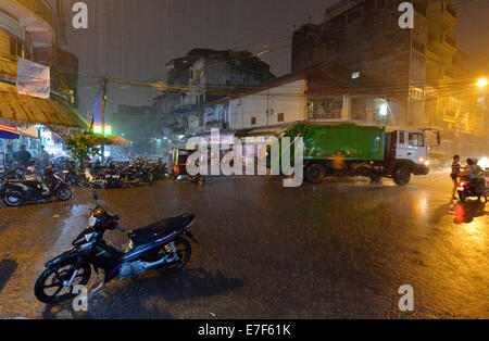 Scena di strada con una strada allagata durante forti piogge monsoniche di notte, il centro città di Phnom Penh, Cambogia Foto Stock