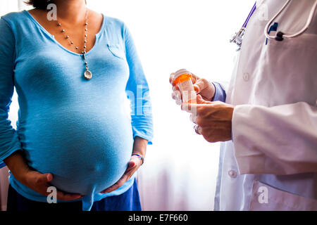 Medico dando una donna incinta medicina di prescrizione Foto Stock