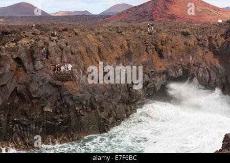 I turisti su un balcone di visualizzazione da una grotta marina in scogliere a Costa Los Hervideros vicino a El Golfo, Lanzarote, Isole Canarie, Spagna Foto Stock