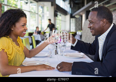 African American giovane tostare ogni altro nel ristorante Foto Stock