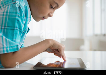 Razza mista boy utilizzando computer tablet Foto Stock