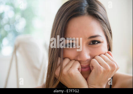 Donna in appoggio mento in mani Foto Stock