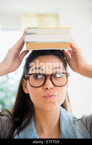 Bilanciamento donna pila di libri sulla sua testa Foto Stock