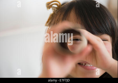 Ragazza filippina cerca attraverso il tubo di cartone Foto Stock