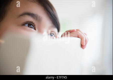 Close up della ragazza filippina il peering su schienale Foto Stock