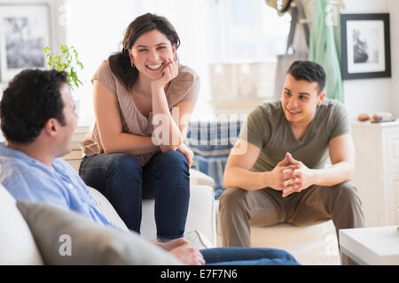 Amici ispanica parlando in salotto Foto Stock