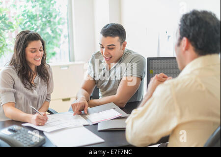 Imprenditore ispanica a parlare con i clienti in ufficio Foto Stock