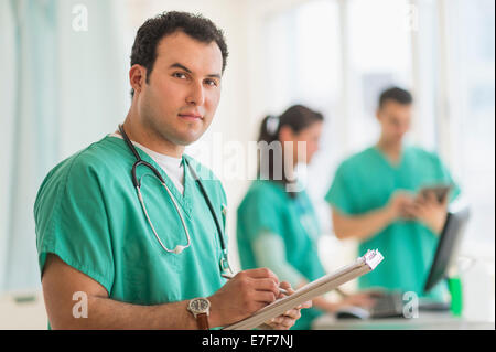 Infermiera ispanica lettura grafico medico in ospedale Foto Stock