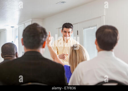 Imprenditrice alzando la mano nella presentazione Foto Stock