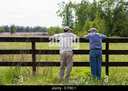 Caucasian padre e figlio appoggiata sulla riga da campo rurale Foto Stock