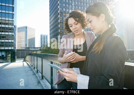 Imprenditrici utilizzando computer tavoletta su urban sky bridge Foto Stock