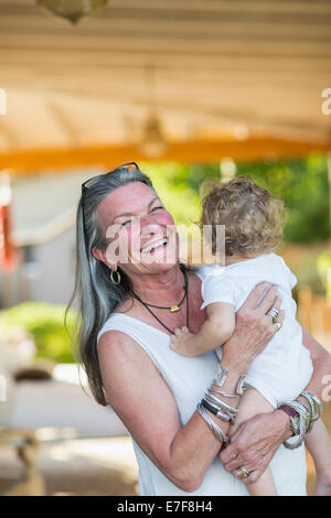 Caucasian donna anziana nipote di contenimento sul portico Foto Stock