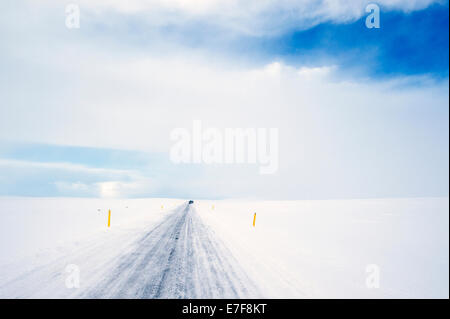 Tracce di pneumatici sulla strada rurale nel paesaggio innevato Foto Stock