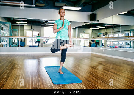 Nero donna a praticare yoga in studio Foto Stock