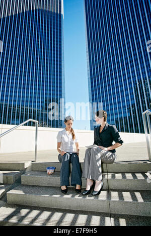 Imprenditrici parlando sulla scalinata della città Foto Stock