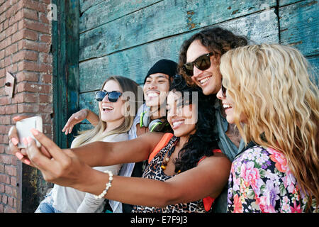 Amici prendendo cellulare picture insieme sulla strada di città Foto Stock