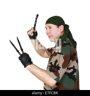 Uomo in camuffamento throw coltelli. Isolato su sfondo bianco Foto Stock