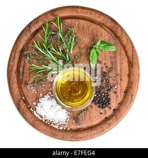 Olio di oliva con erbe fresche timo, basilico e rosmarino cucina in legno board Foto Stock