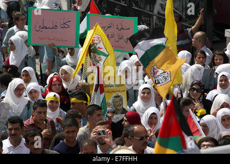 Nablus, West Bank, Territorio palestinese. 16 Sett 2014. Sostenitori palestinese del movimento Fatah tenere il movimento di bandiere durante una manifestazione di protesta per la marcatura del 48esimo anniversario dei massacri di Sabra e Shatila nel 1982, in Cisgiordania città di Nablus, 16 settembre 2014. I massacri di Sabra e Shatila è stata la macellazione di tra 762 e 3.500 civili, soprattutto palestinesi e sciiti libanesi, dal partito Kataeb, un libanese milizia cristiana, nel quartiere di Sabra e Shatila adiacenti campo profughi a Beirut, in Libano. Credito: ZUMA Press, Inc./Alamy Live News Foto Stock