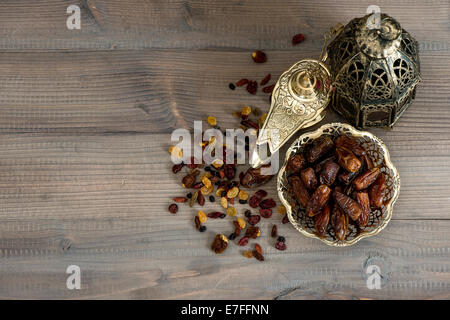 Vita Tranquilla con l'annata oriental lanterna e mulino. uvetta e date su sfondo di legno Foto Stock