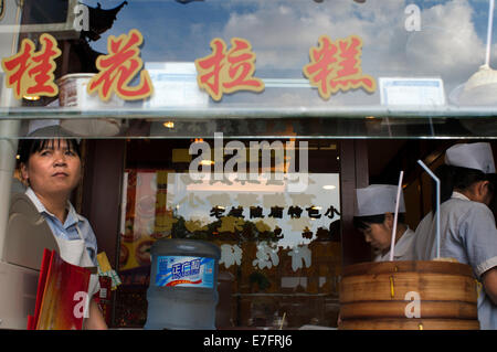 Ristorante nella città vecchia di Shanghai. Sistema per la cottura a vapore in bambù vassoi con dim sum scelte a piccolo ristorante in città ex tempio di Dio su Foto Stock